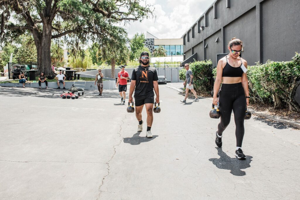 Two athletes carrying kettlebells during the Rox Race at Iron Legion Strength and Combat in Ocala Florida